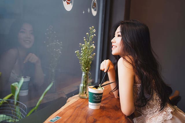 happy woman smiling outside window on solo coffee date