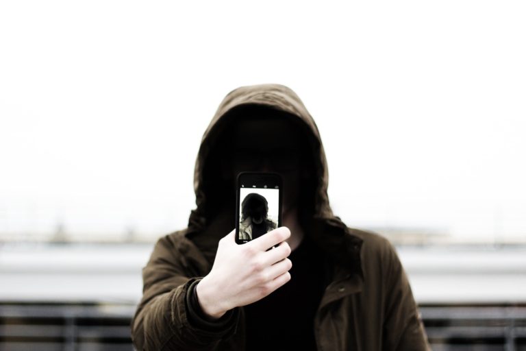 guy with hoodie hidden face taking selfie