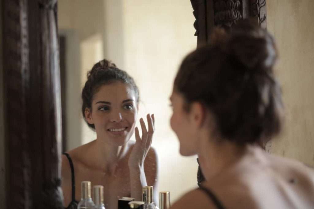 woman looking at herself in the mirror