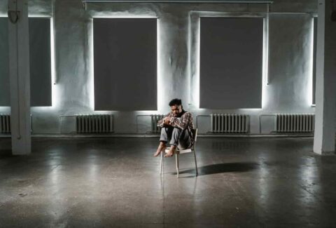 Man sitting alone on chair in middle of the room