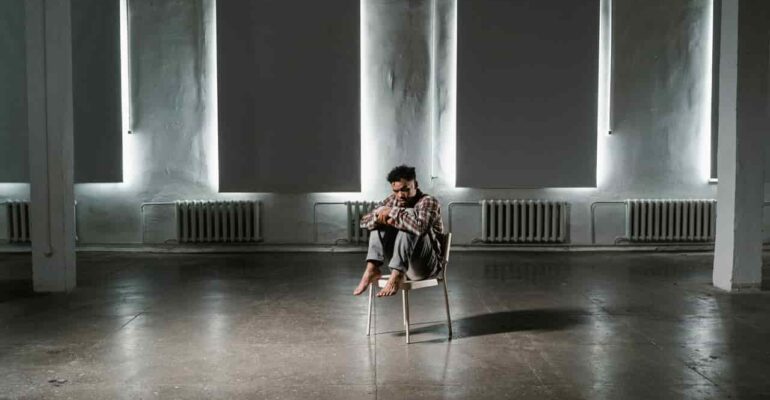 Man sitting alone on chair in middle of the room