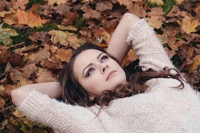 girl lying down on autumn leaves reflecting on resentment