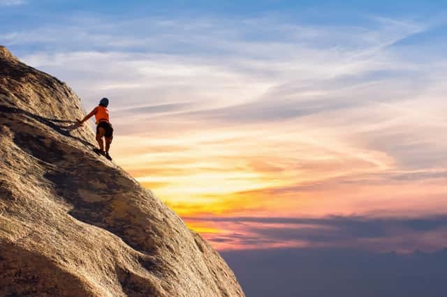 woman climbing rocky mountain self challenge