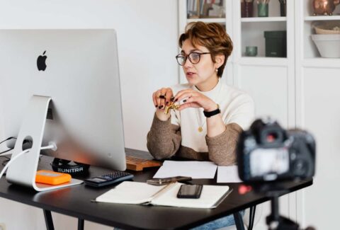 woman behind desk working on laptop doing mindset online coaching