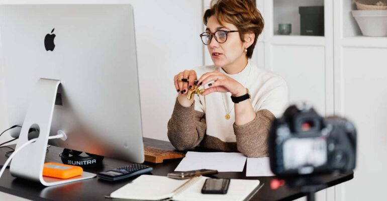 woman behind desk working on laptop doing mindset online coaching