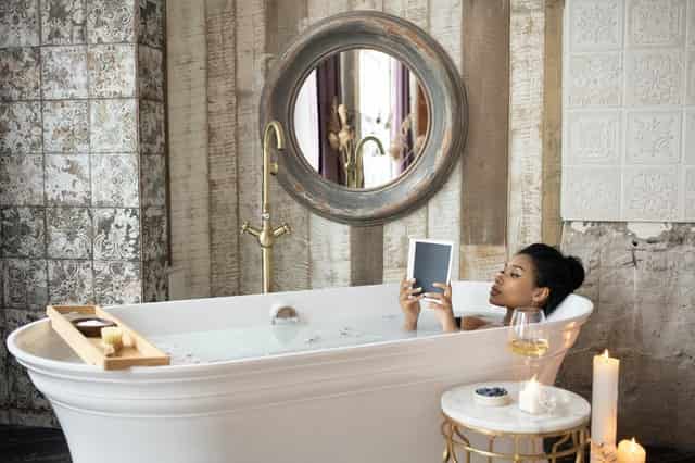 woman in bath holding her ipad having a self love conscious conversation