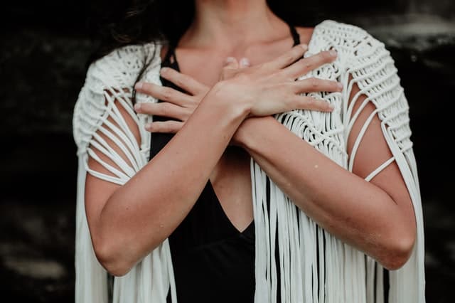 woman crossing her hands on her chest resting in faith to achieve her goals