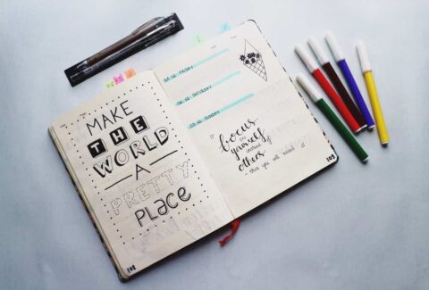 a journal with words written: "make the world a better place, focus on yourself instead of others."