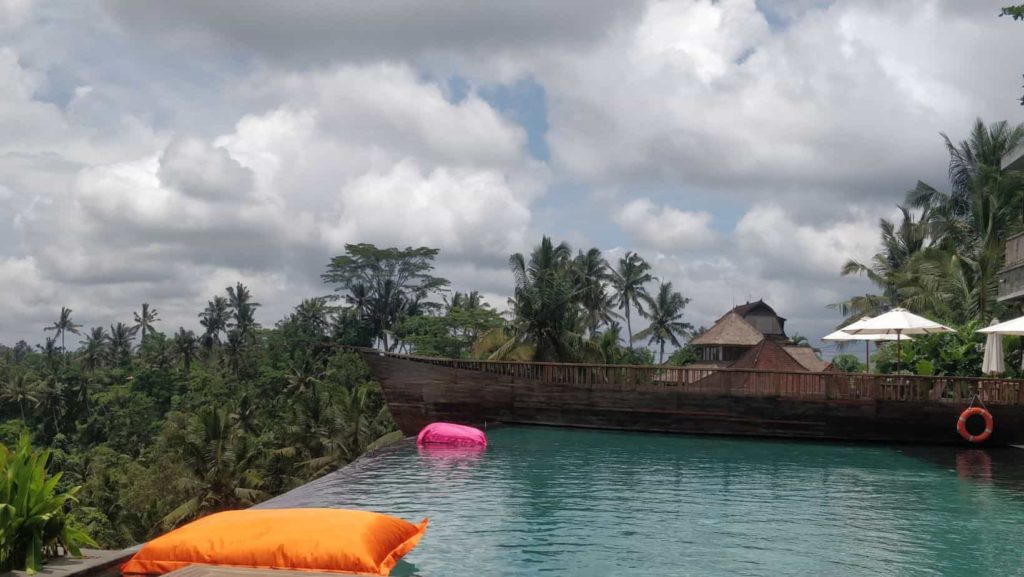 Ubud Bali photo with palm trees, pool and a boat shaped restaurant