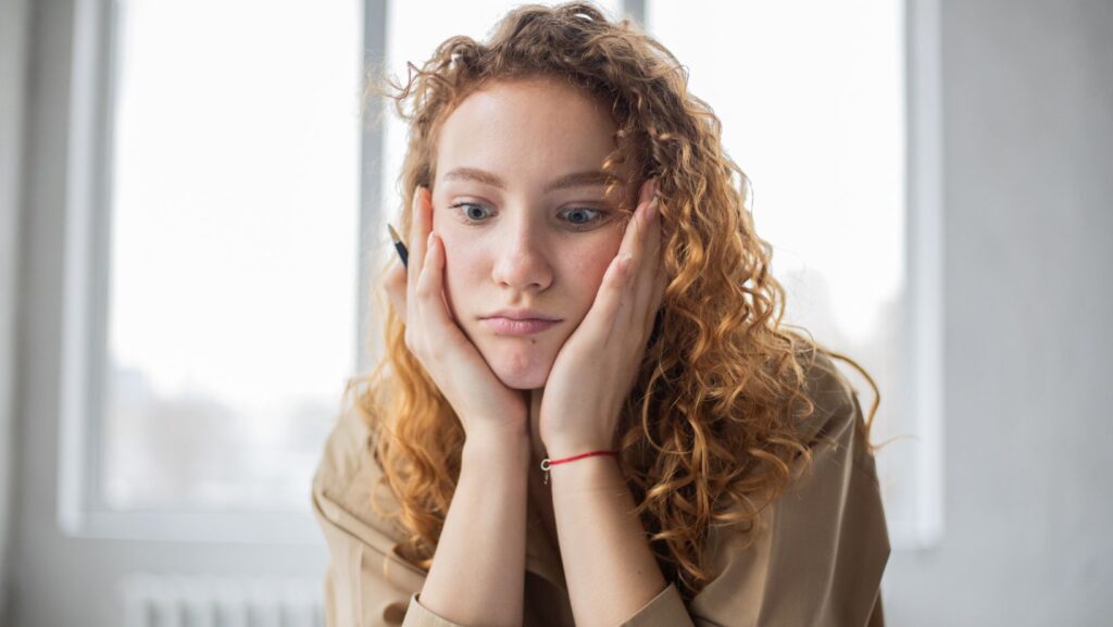 a girl confused about quitting her 9 to 5 job staring blankly