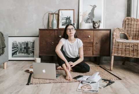 A woman on the floor with her laptop reflecting on how to break codependency