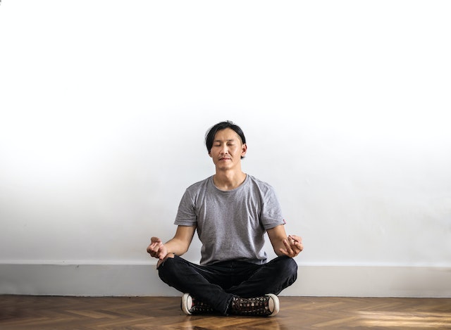 a man in lotus position practicing mindfulness meditation