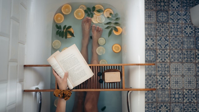 a woman in a bath infused with citrus fruits and leaves as a self care practice which helps you navigate through spiritual awakening stages