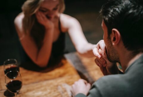 a woman handing her hand over the table to her narcissistic partner showing sad emotions and concern due to narcissistic traits