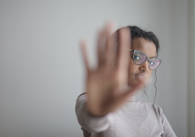 a woman putting her hand out implying that she wants to stop abuse control and manipulation