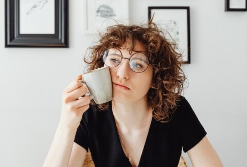 a woman thinking holding a mug in her hand next to her face staring blankly and thinking about things covert narcissists say