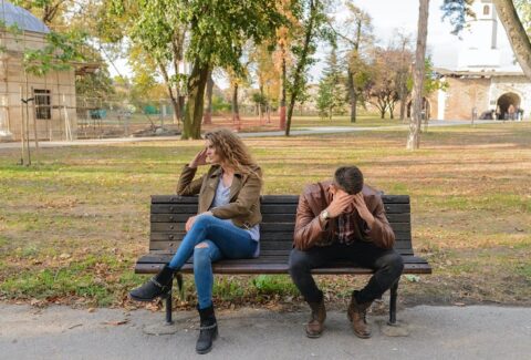 a couple on a bench in the park arguing